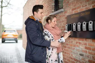 a man and a woman standing next to a brick wall at Logement Den Beer in Meerhout