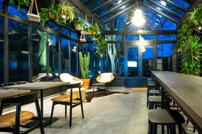 a restaurant with tables and chairs and plants at Logement Den Beer in Meerhout