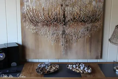 a chandelier hanging from a wall with two plates of food at villa 2be in Balen