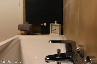 a bathroom sink with a clock on top of it at villa 2be in Balen