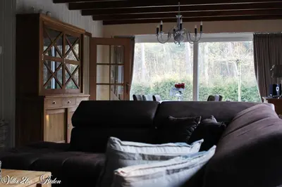 a living room with a couch and a large window at villa 2be in Balen