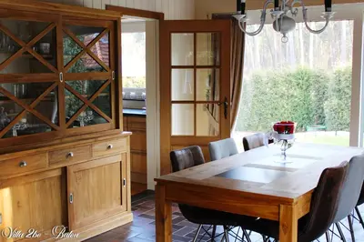 a dining room with a table and a large glass cabinet at villa 2be in Balen