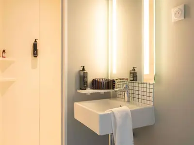 a bathroom with a white sink and a mirror at ibis budget Leuven Centrum in Leuven