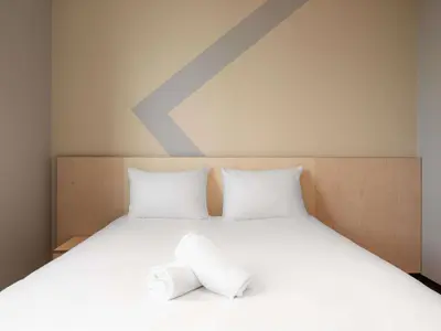 a bed with two pillows on top of it at ibis budget Leuven Centrum in Leuven