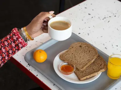 a tray with a plate of bread and a cup of coffee at ibis budget Leuven Centrum in Leuven
