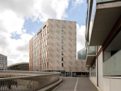 a tall building with a walkway in front of it at ibis budget Leuven Centrum in Leuven