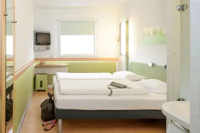 a hospital room with two beds and a television at ibis budget Antwerpen Centraal Station in Antwerp