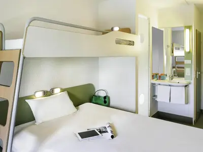 a room with a bed with a camera on it at ibis budget Antwerpen Port in Antwerp