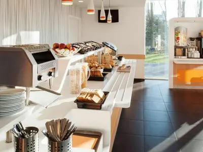 a kitchen with a counter with bread and pastries at ibis budget Antwerpen Port in Antwerp