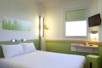 a bedroom with a white bed and a window at ibis budget Antwerpen Port in Antwerp