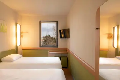a hotel room with two beds and a window at ibis budget Antwerpen Port in Antwerp