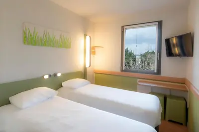a hotel room with two beds and a window at ibis budget Antwerpen Port in Antwerp