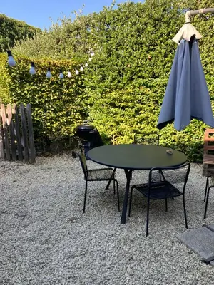a table and two chairs and an umbrella at Van Hamme 1642 - house for 2 to 4 persons in Kortenberg