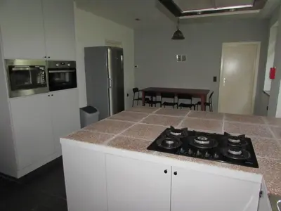 a kitchen with a stove and a counter top at De Spreekkamer in Hoogstraten