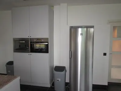 a kitchen with a stainless steel refrigerator and a microwave at De Spreekkamer in Hoogstraten