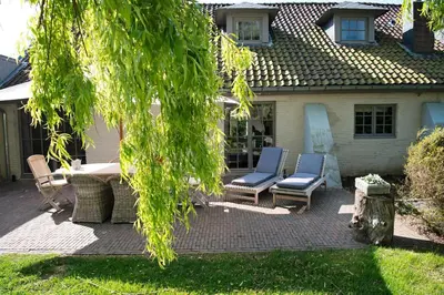a patio with two chairs and a table and a table at B&B De Hanewijkhoeve in Werchter
