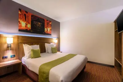 a hotel room with a large bed and a television at Hotel Opera Antwerpen Centrum in Antwerp