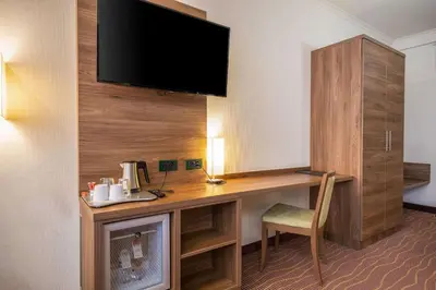 a room with a desk with a tv and a chair at Hotel Opera Antwerpen Centrum in Antwerp