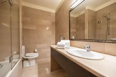a bathroom with a sink and a toilet and a mirror at Hotel Opera Antwerpen Centrum in Antwerp
