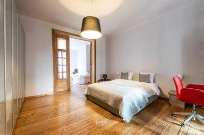 a bedroom with a bed and a red chair at Rez/duplex 3 ch et jardin in Brussels