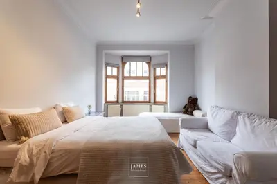 a bedroom with a large bed and a couch at Rez/duplex 3 ch et jardin in Brussels