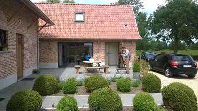 a man taking a picture of a man in front of a house at Logies Berckelaer in Sint-Gillis-Waas
