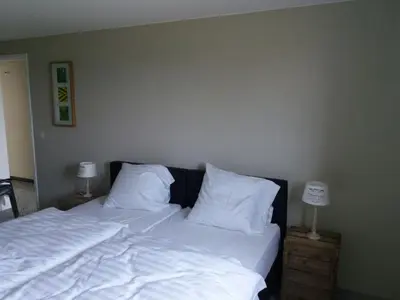 a bedroom with a bed with white sheets and pillows at Logies Berckelaer in Sint-Gillis-Waas