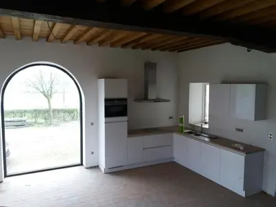 a kitchen with white cabinets and an open door at Logies Berckelaer in Sint-Gillis-Waas