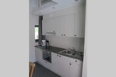 a kitchen with white cabinets and a sink at Logies Berckelaer in Sint-Gillis-Waas