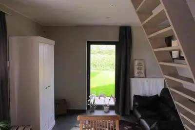 a living room with a couch and a window at Logies Berckelaer in Sint-Gillis-Waas