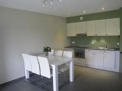 a kitchen with a white table and white chairs at Logies Berckelaer in Sint-Gillis-Waas