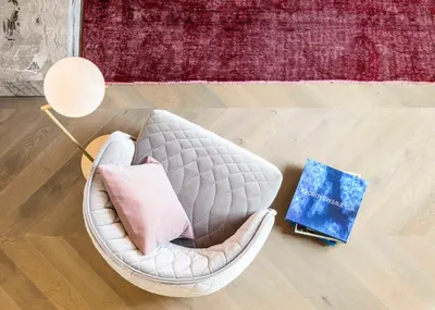 a chair with a pillow and a book on the floor at Gulde Schoen Luxury Studio-apartments in Antwerp