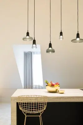 a kitchen with pendant lights and a counter with a chair at Gulde Schoen Luxury Studio-apartments in Antwerp