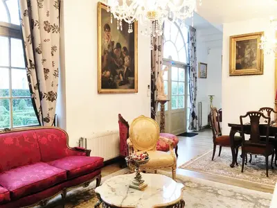 a living room with a red couch and a table at Koetshuis Bosdam in Beveren