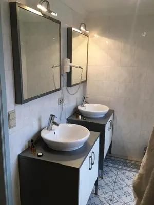 a bathroom with two sinks and a mirror at Koetshuis Bosdam in Beveren