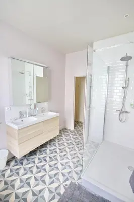 a white bathroom with a sink and a shower at La maison du fond du jardin in Brussels