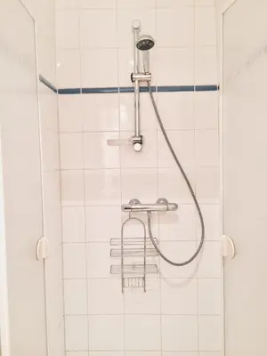 a shower in a bathroom with white tiles at Bijou Brussels > Parvis St Pierre in Brussels