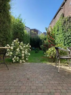 a patio with two benches and flowers in a garden at Bijou Brussels > Parvis St Pierre in Brussels