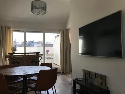 a living room with a table and a television on a wall at Sainte Catherine amazing view in Brussels