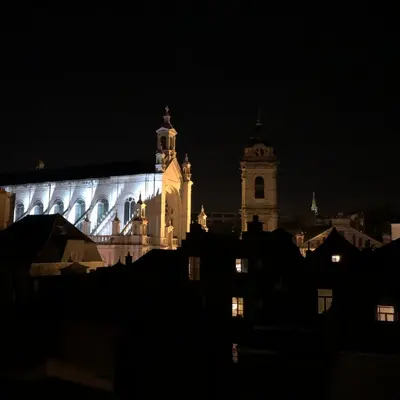 a large building with a clock tower at night at Sainte Catherine amazing view in Brussels
