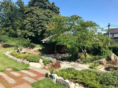 a garden with a small cabin in the background at B&B Tolkantoor in Zelzate