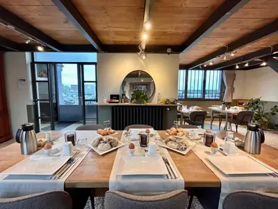 a dining room with a large wooden table and chairs at B&B Tolkantoor in Zelzate