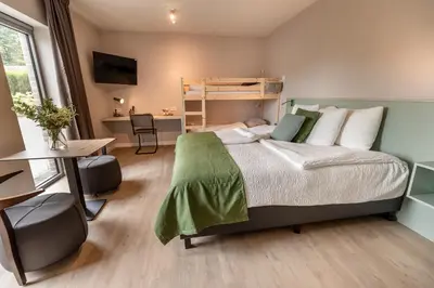 a bedroom with a bed with a desk and a desk at Abalona Hotel & Apartments in Dendermonde