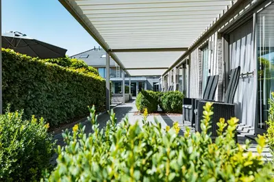 a building with benches and bushes next to a building at Abalona Hotel & Apartments in Dendermonde
