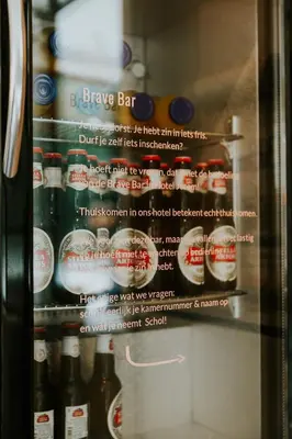 a refrigerator filled with lots of bottles of soda at Hotel Jerom in Kalmthout
