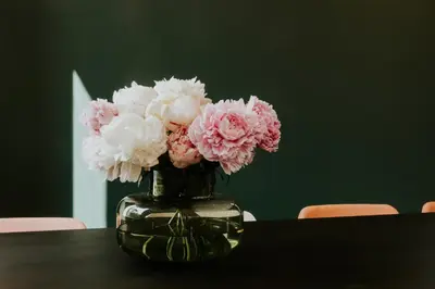 a vase filled with pink and white flowers on a table at Hotel Jerom in Kalmthout