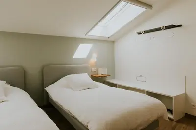 a bedroom with two beds and a window at Hotel Jerom in Kalmthout