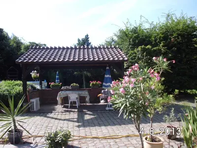 a garden with a gazebo with a table and umbrella at 't Vliethuys in Zwijndrecht