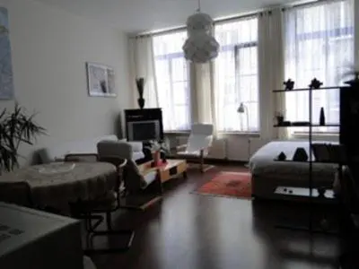 a living room with a couch and a table at B&B La Villa Zarin in Brussels