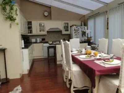 a kitchen with a dining table with a red table cloth at B&B La Villa Zarin in Brussels